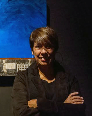 Fotografía de la artista junto a su obra