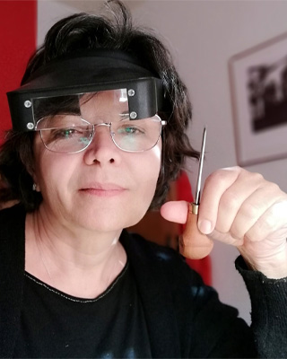 Fotografía de la artista con una gubia de grabado en la mano
