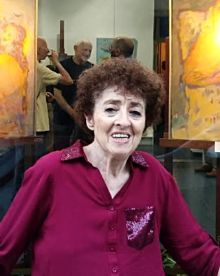 Fotografía de la artista junto a su obra